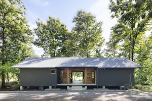 The Grey Wooden House Offers Tranquility within the Forest