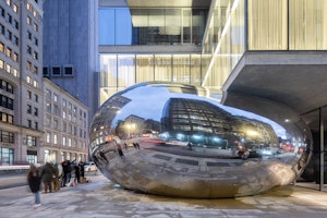 A Sculpture Shaped Like a Giant Balloon Squished by a Skyscraper