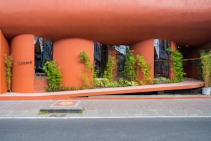 Savor Sweet Moments at The Merlot Pods, A Vibrant Red Stucco Building